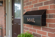 Dark patina copper mailbox with embossed MAIL - installed on residential house wall