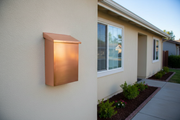 Vertical Brushed Copper Mailbox on Painted Wall